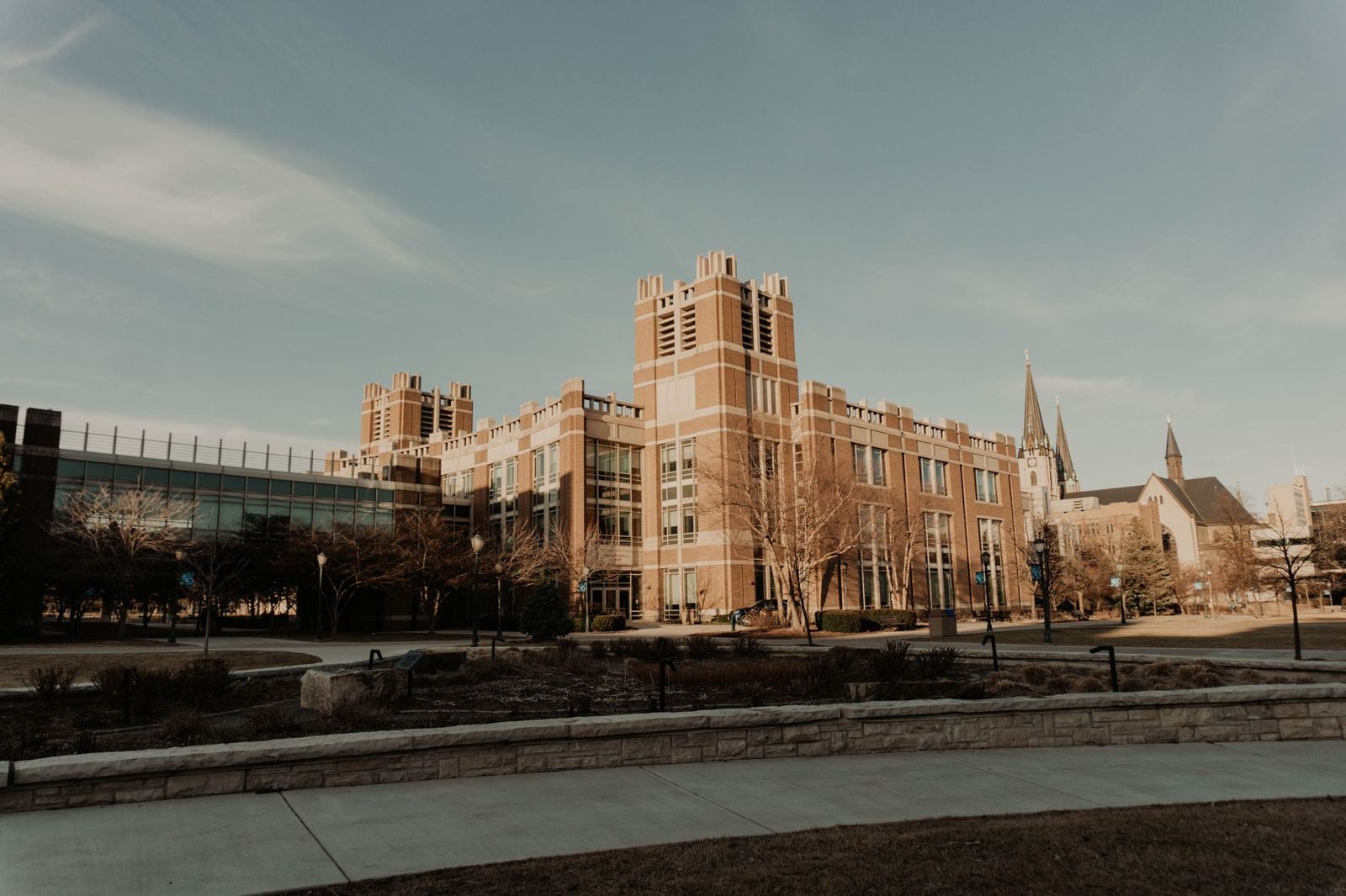 A brick collegiate building and open plaza on a winter afternoon