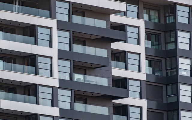 Rows of glass-railed balconies on a modern apartment building