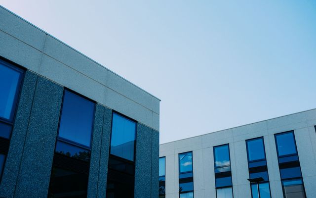 Two stone-and-glass medical office buildings against a clear evening sky