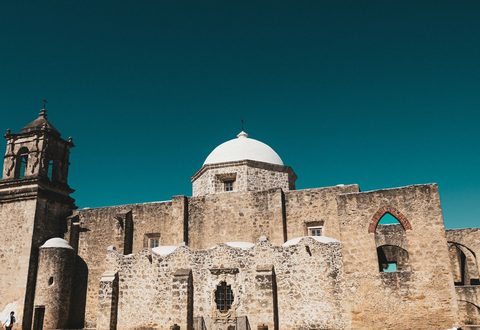 The stone church and bell tower of Mission San Jose in San Antonio